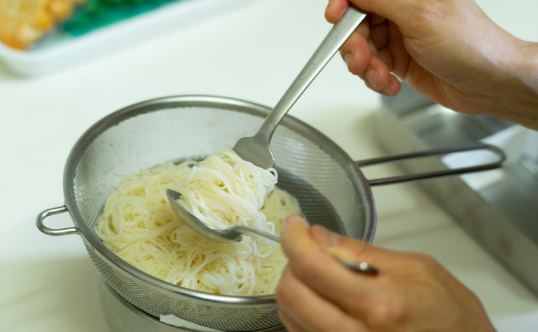 2.  スプーンの上にフォークで麺を乗せ、くるくると巻く