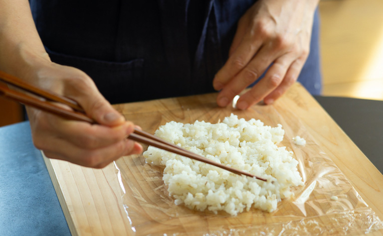 2.  お茶碗一杯分の酢飯をラップの上に広げる。